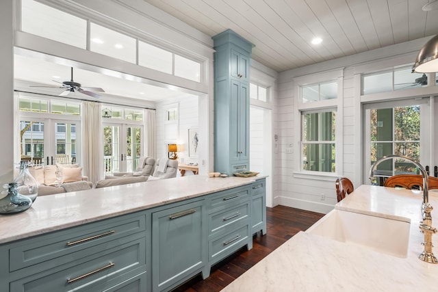 kitchen featuring dark wood-type flooring, a sink, wood ceiling, open floor plan, and french doors