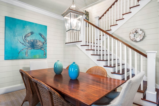 dining area featuring wood walls and an inviting chandelier