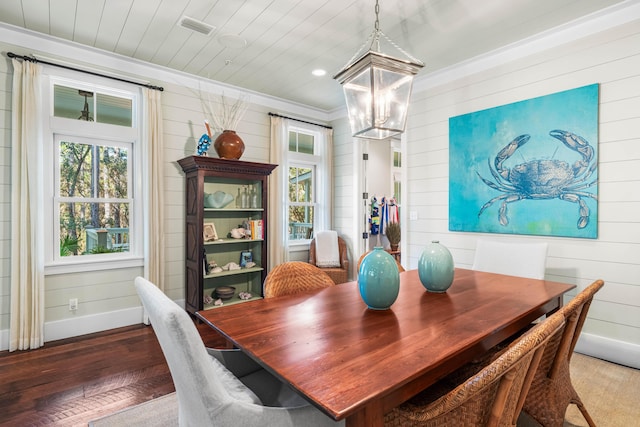 dining space featuring wooden ceiling, wood finished floors, baseboards, an inviting chandelier, and crown molding