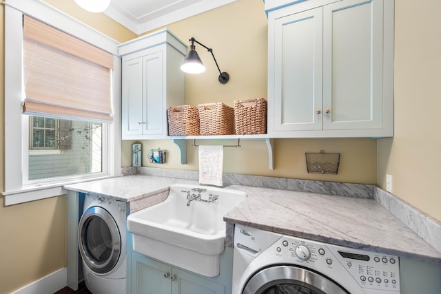 laundry area featuring a sink, washing machine and clothes dryer, and cabinet space