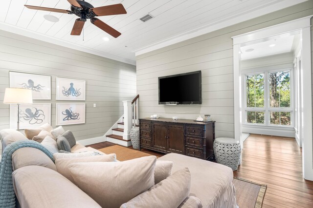 living area featuring light wood-style flooring, stairway, visible vents, and baseboards