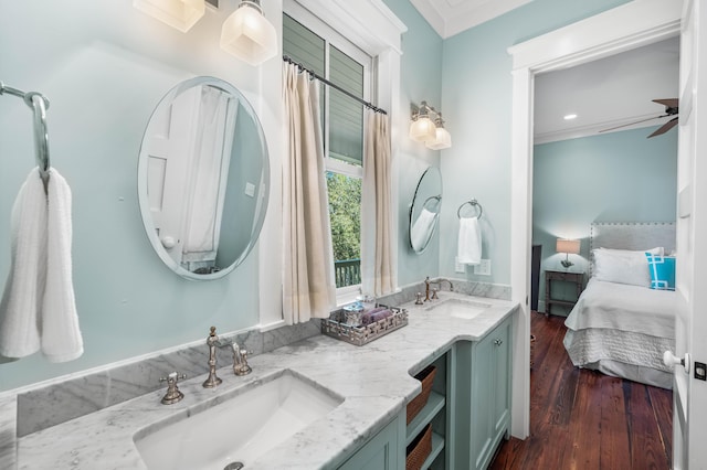 ensuite bathroom with ornamental molding, wood finished floors, a sink, and ensuite bathroom