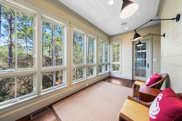 sunroom / solarium with wood ceiling, a wealth of natural light, and visible vents