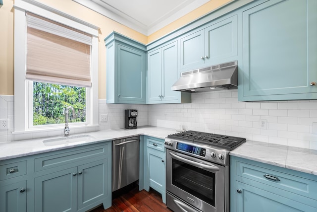 kitchen featuring tasteful backsplash, appliances with stainless steel finishes, light stone countertops, under cabinet range hood, and a sink