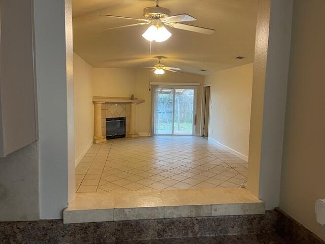 unfurnished living room with lofted ceiling, light tile patterned floors, and ceiling fan