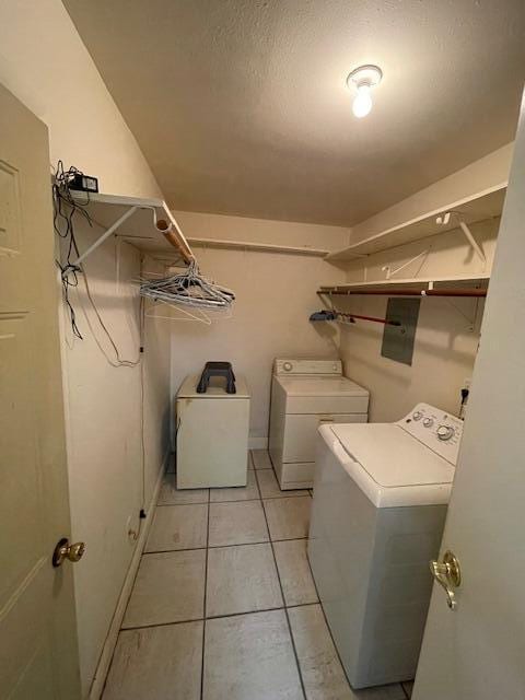 laundry area featuring light tile patterned flooring and washing machine and clothes dryer