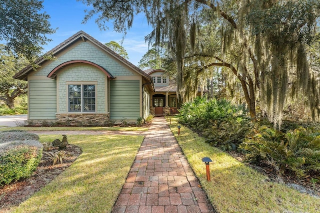 craftsman-style home with stone siding and a front yard