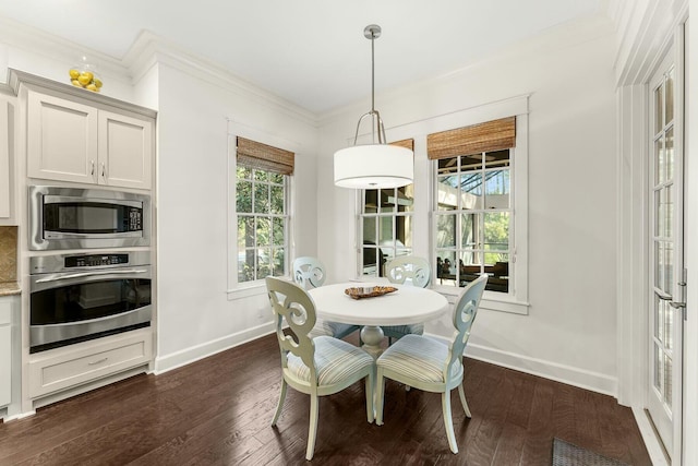 dining room featuring dark wood-type flooring, baseboards, and ornamental molding