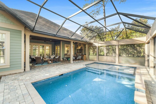 pool featuring glass enclosure, a patio, ceiling fan, and an outdoor hangout area