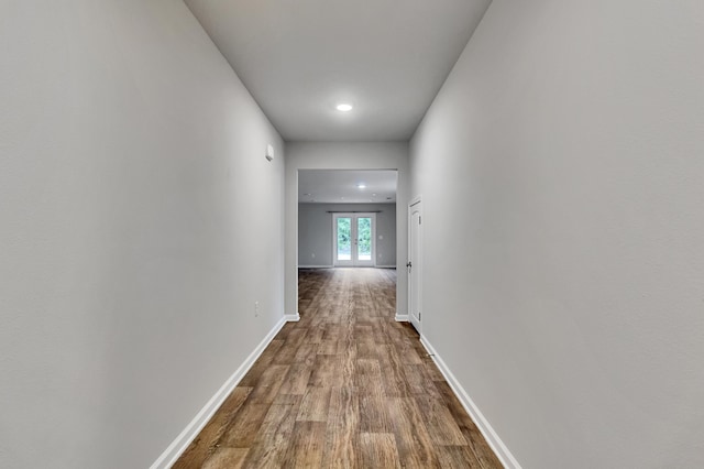 corridor with hardwood / wood-style flooring and french doors