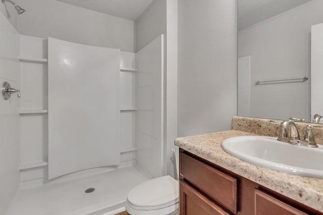 bathroom with a shower, vanity, and toilet