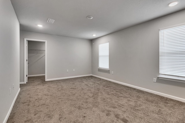 unfurnished bedroom featuring a spacious closet, a closet, and carpet flooring