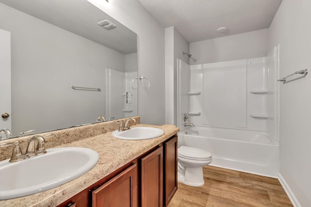 full bathroom featuring wood-type flooring, toilet, shower / bath combination, and vanity