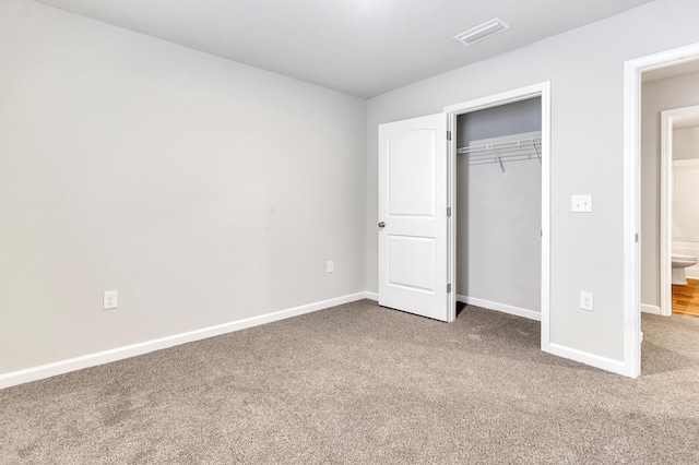 unfurnished bedroom featuring carpet flooring and a closet