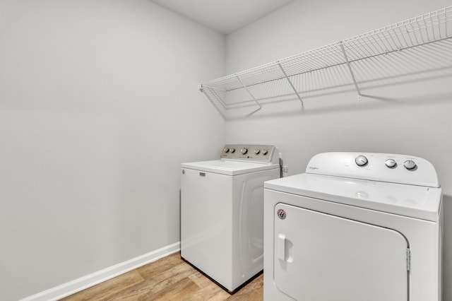 laundry area featuring washing machine and dryer and light wood-type flooring