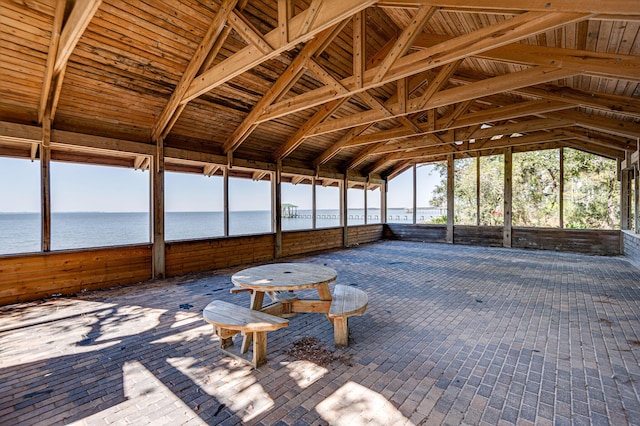 unfurnished sunroom with a water view and lofted ceiling