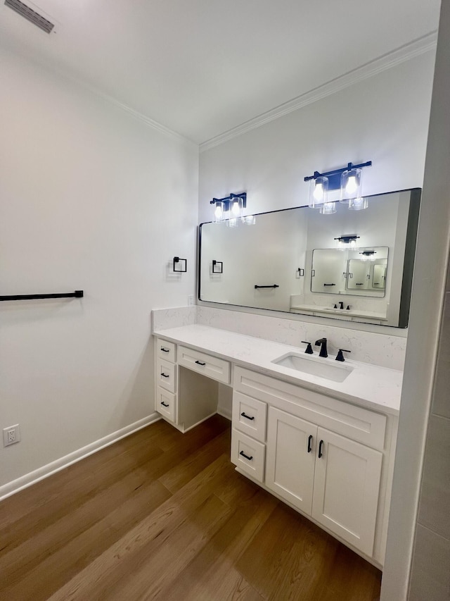 bathroom with hardwood / wood-style flooring, crown molding, and vanity