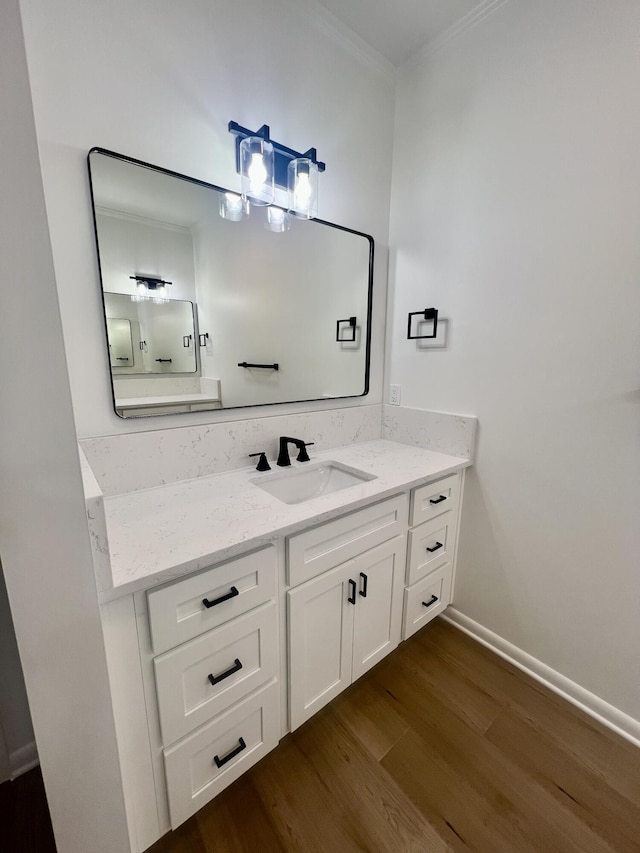 bathroom with hardwood / wood-style flooring, vanity, and crown molding