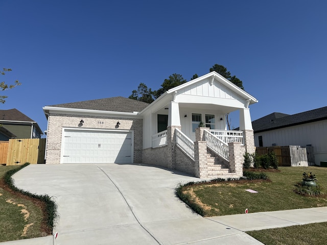 view of front of home featuring covered porch, a front lawn, and a garage