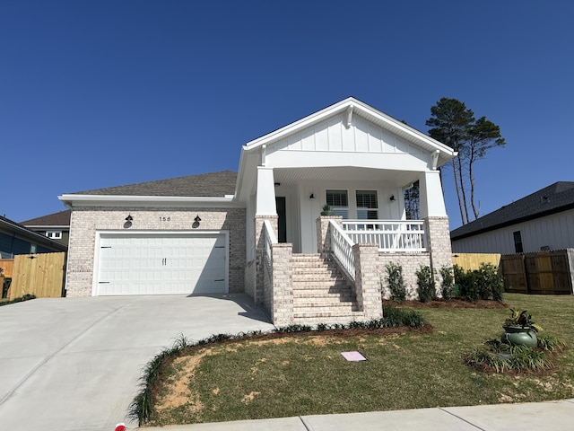 view of front of home featuring a front lawn, a garage, and a porch