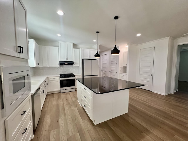 kitchen with stainless steel appliances, white cabinetry, and a center island