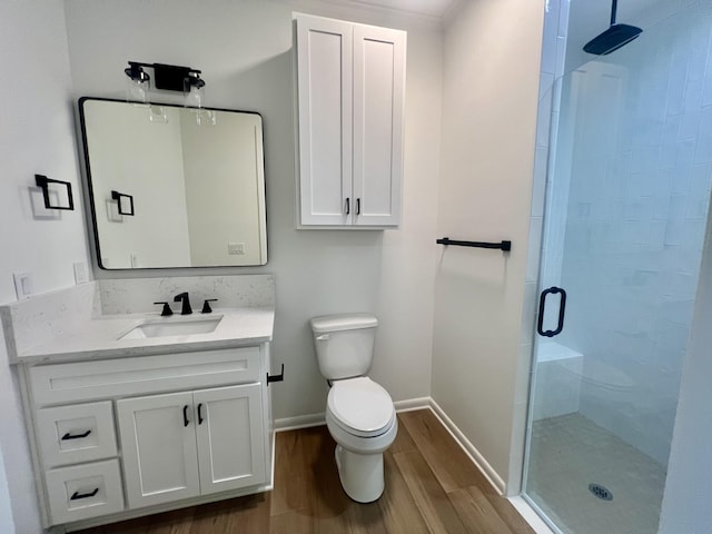 bathroom featuring toilet, vanity, an enclosed shower, and wood-type flooring