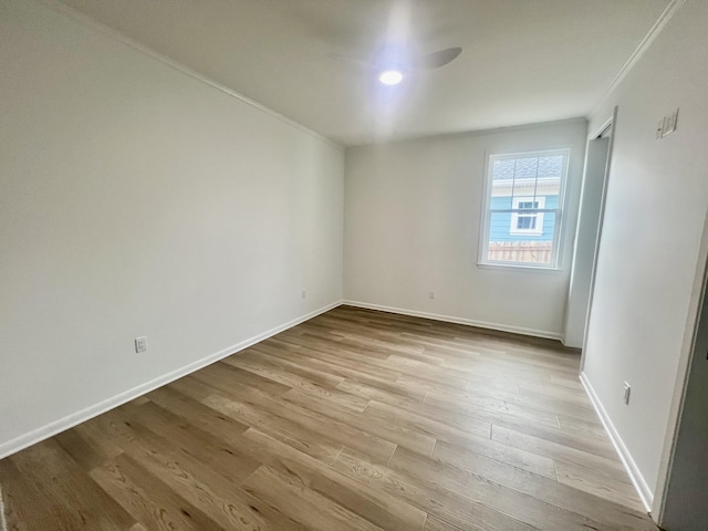 unfurnished room with light wood-type flooring and crown molding