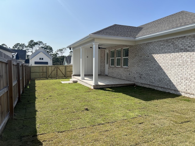 rear view of house featuring a yard, a patio, and ceiling fan