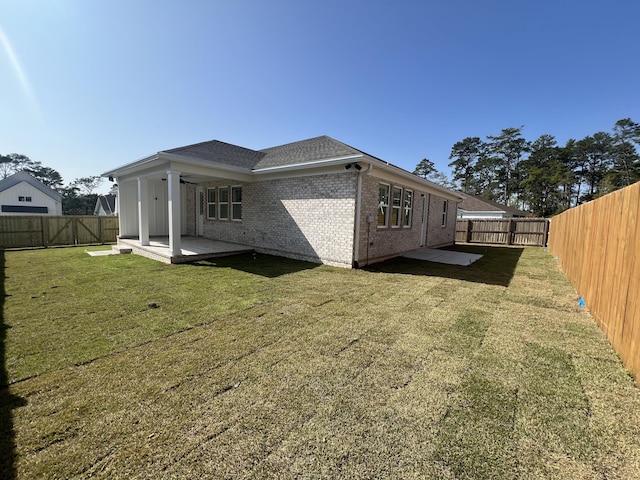 rear view of house with a patio area and a lawn