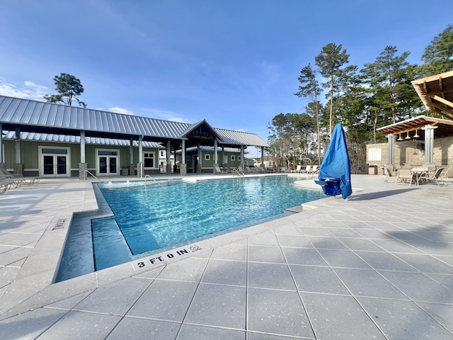 view of pool featuring a patio area and french doors