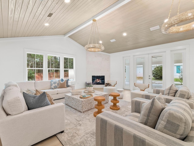 living room featuring light hardwood / wood-style flooring, vaulted ceiling with beams, french doors, a large fireplace, and wood ceiling