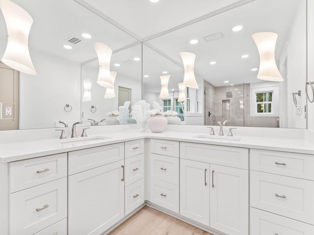 bathroom with vanity, wood-type flooring, and a shower with shower door