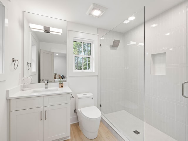 bathroom featuring toilet, an enclosed shower, vanity, and wood-type flooring