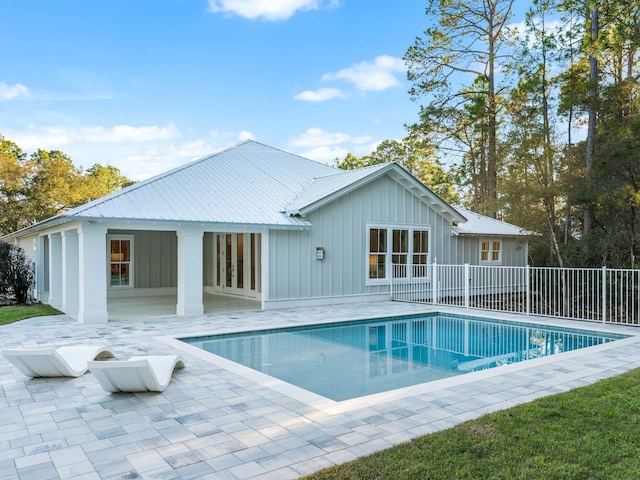 rear view of house featuring a patio and a fenced in pool