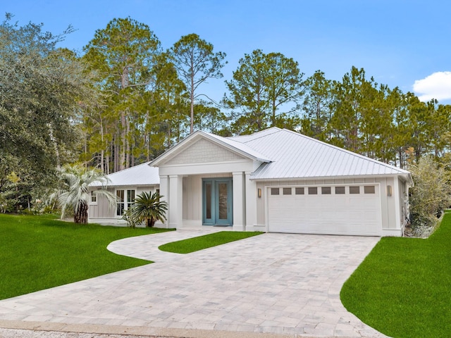 view of front of home with a front yard, french doors, and a garage