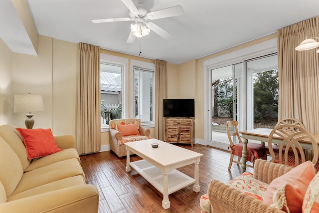 living room featuring ceiling fan and dark wood-type flooring