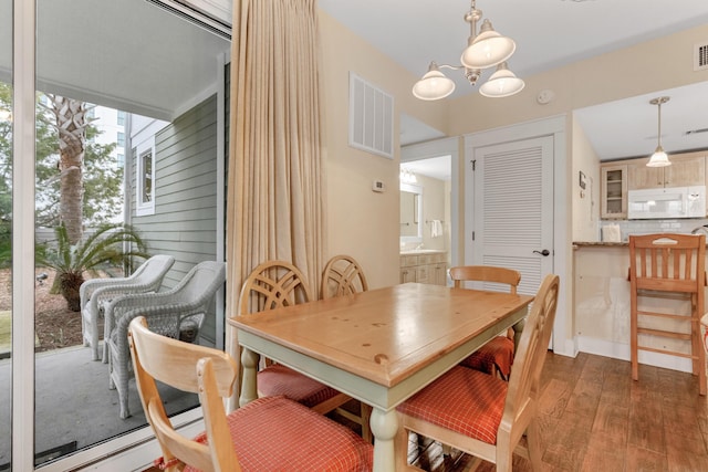 dining area featuring a notable chandelier and dark hardwood / wood-style floors