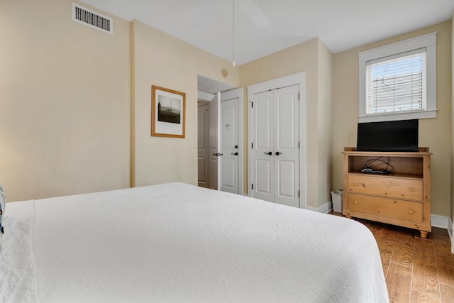 bedroom featuring dark hardwood / wood-style flooring and multiple closets