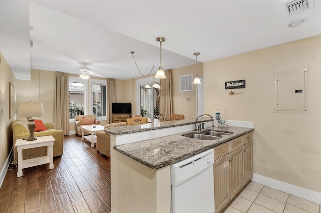 kitchen with electric panel, sink, white dishwasher, kitchen peninsula, and light stone countertops