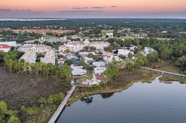 aerial view at dusk featuring a water view