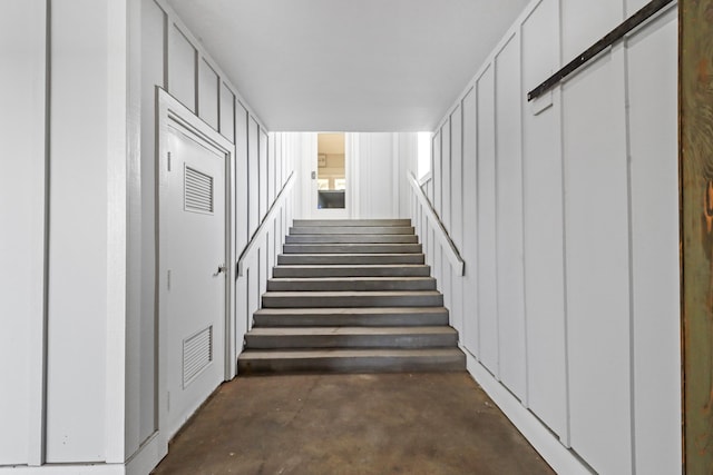 staircase featuring concrete flooring