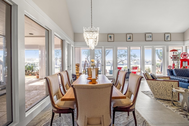 dining area featuring plenty of natural light, lofted ceiling, a chandelier, and french doors