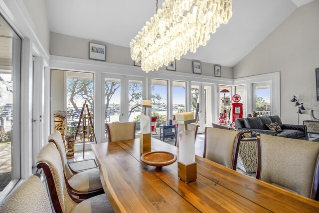 dining room with a notable chandelier, high vaulted ceiling, and french doors