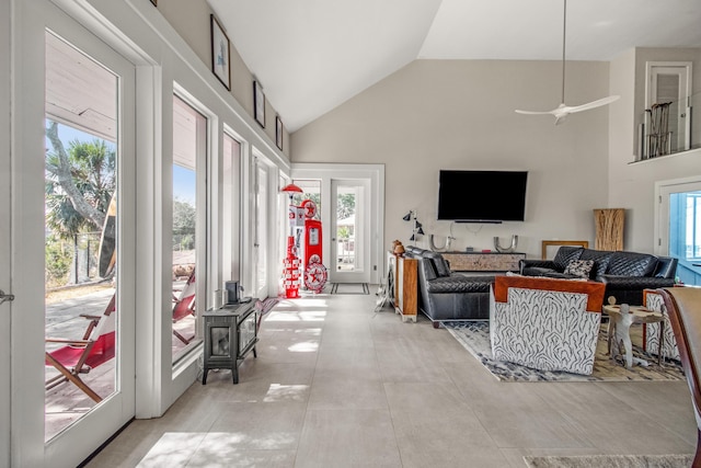 living room with light tile patterned flooring, ceiling fan, and high vaulted ceiling