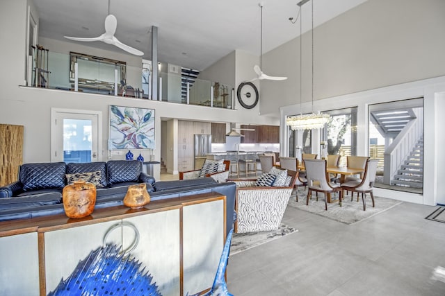 living room with ceiling fan and a high ceiling