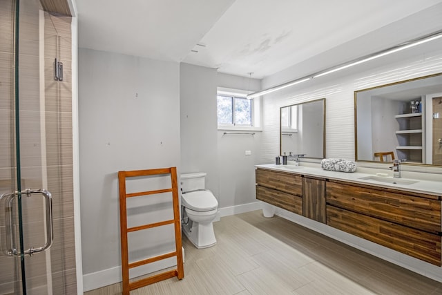 bathroom featuring a shower with door, vanity, and toilet