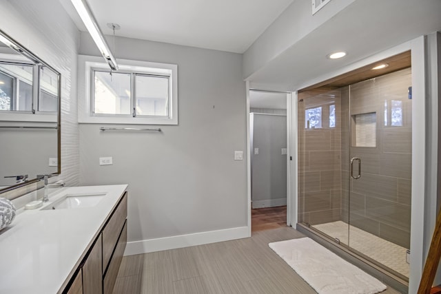 bathroom featuring vanity and a shower with door