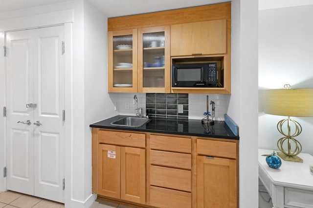 kitchen featuring sink, light tile patterned floors, and decorative backsplash