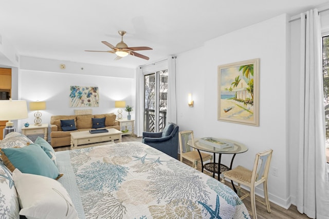 bedroom featuring hardwood / wood-style flooring, access to exterior, and ceiling fan