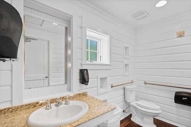 bathroom featuring crown molding, toilet, and sink